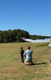 Children watching a smoke-pass at a fly-in